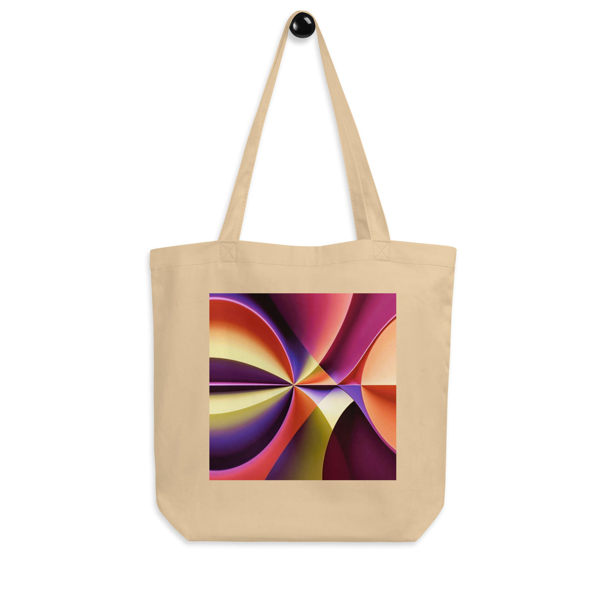 Story of Colour cream tote bag hanging from a wall hook, showing the geometric print and long straps.
