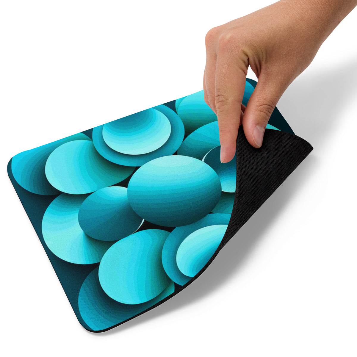 Hand lifting the corner of the Echoes Mouse Pad showing the non-slip black rubber base.
